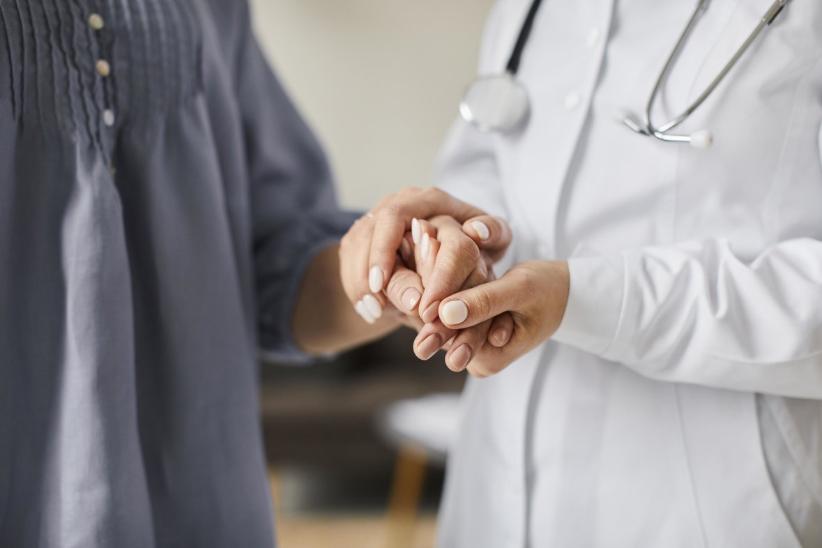 female doctor holding patient hands