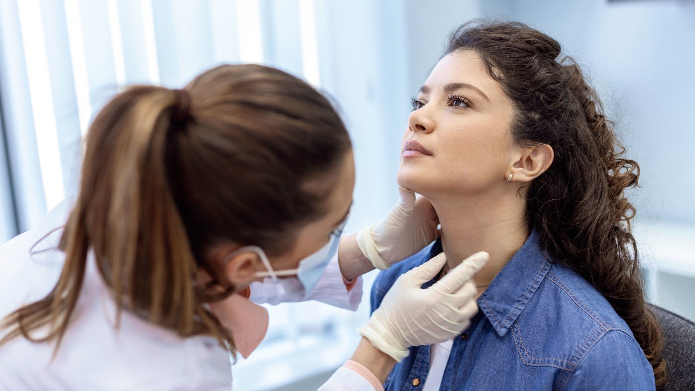 Doctor examining a woman's neck