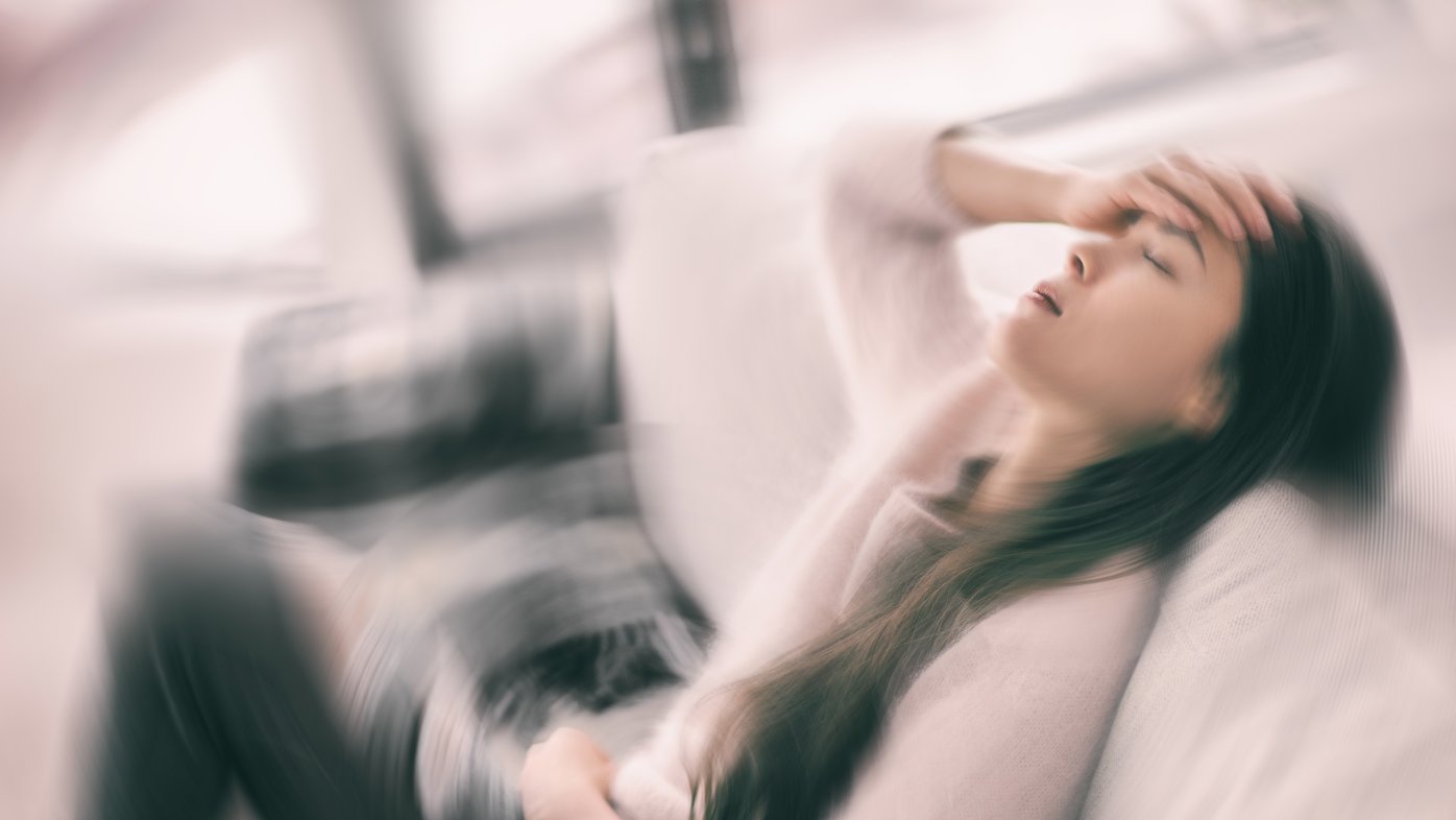 Woman sitting down feeling dizzy