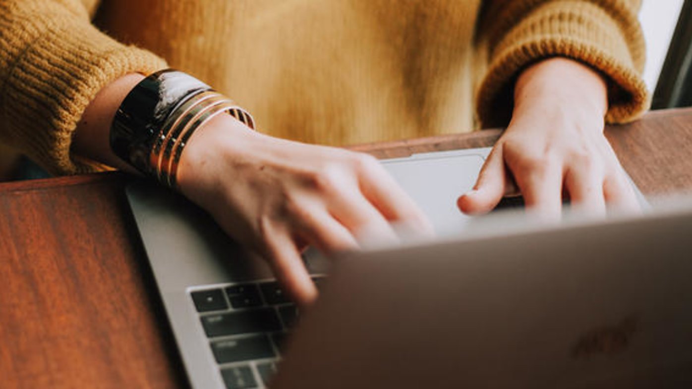 A woman's hands type on a laptop computer