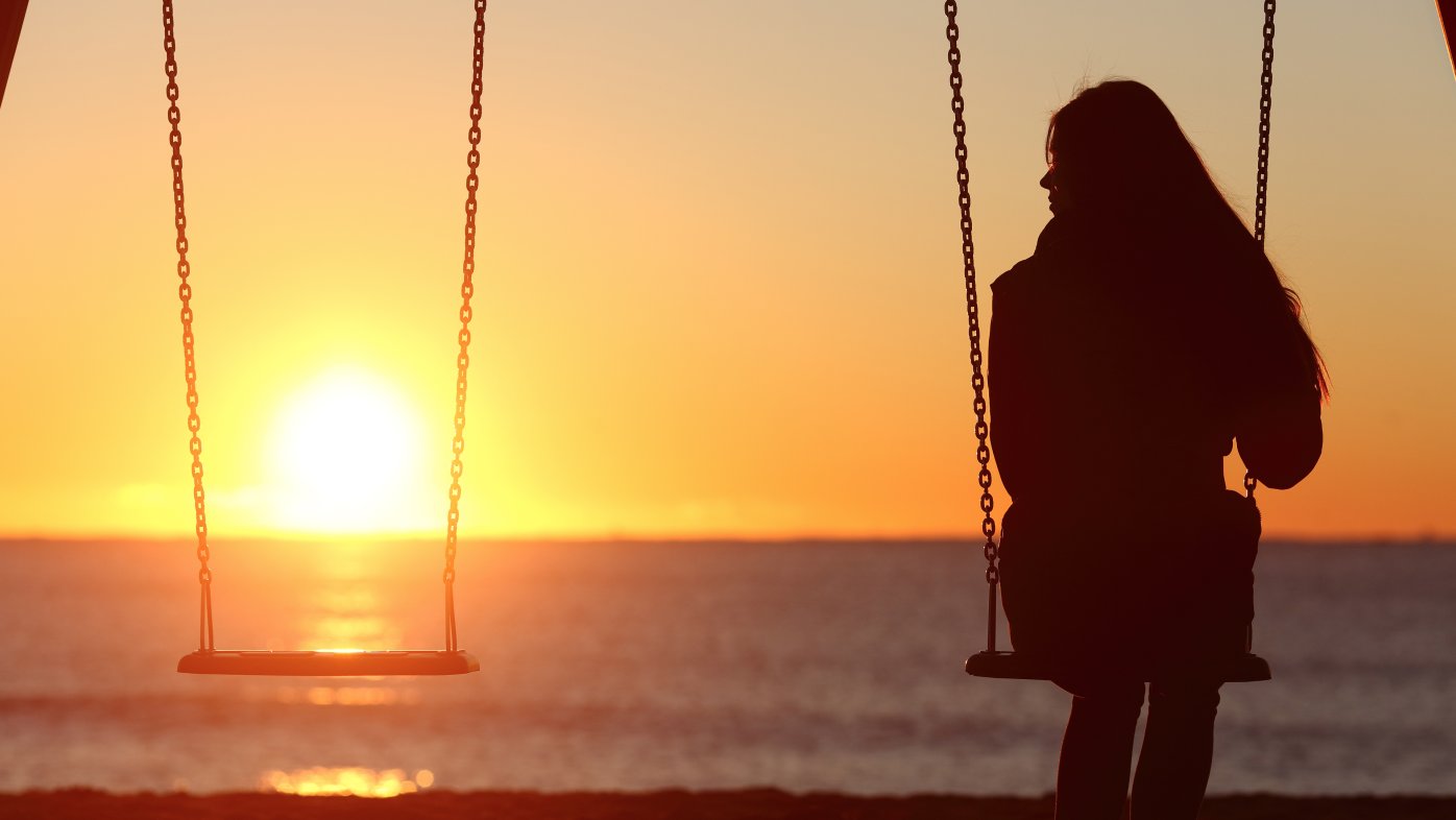 Teenager at the beach on a swing