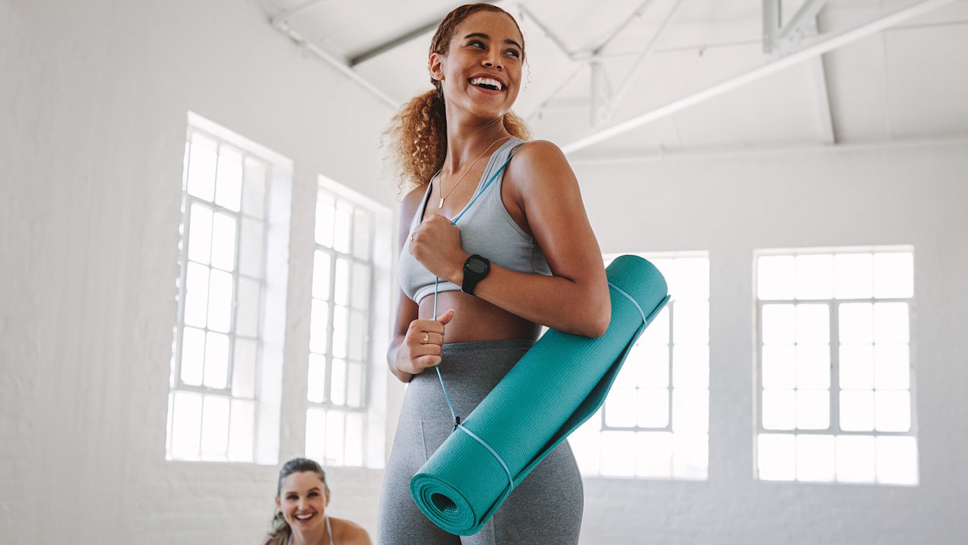 Woman in an exercise studio with a yoga mat