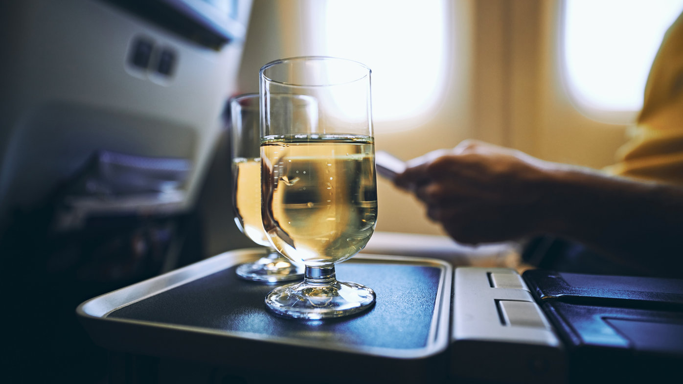 Glasses of white wine on an airplane tray