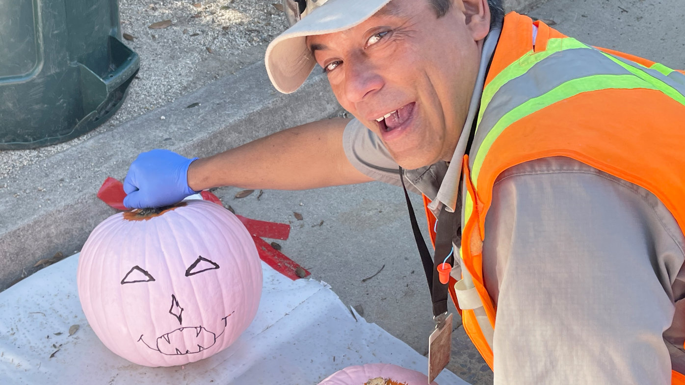 A landscaper at Sharp Grossmont Hospital with a pink pumpkin
