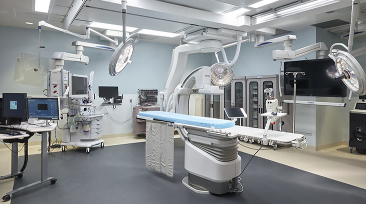 Operating room with operating table, equipment, work station and three lights