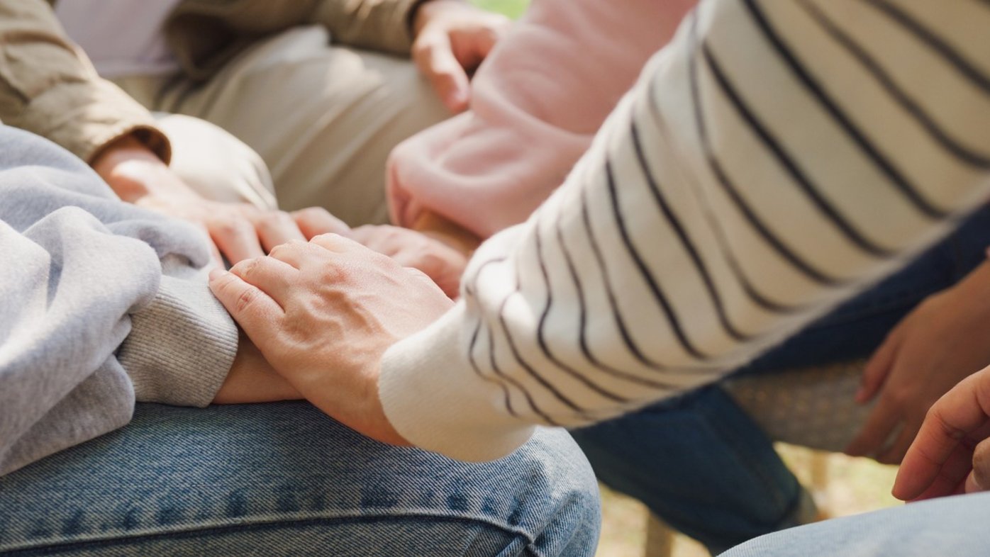 People holding hands in support group