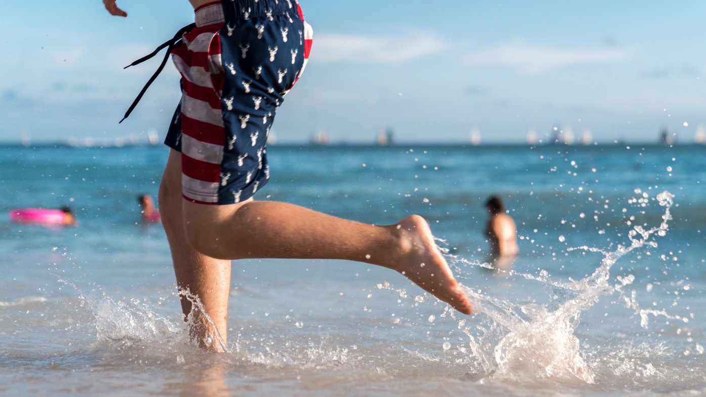 Person running on the beach in a patriotic swimsuit