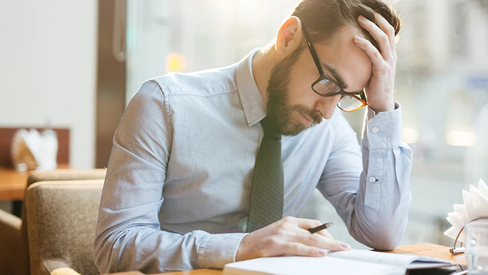 Stressed businessman holding head up with hand