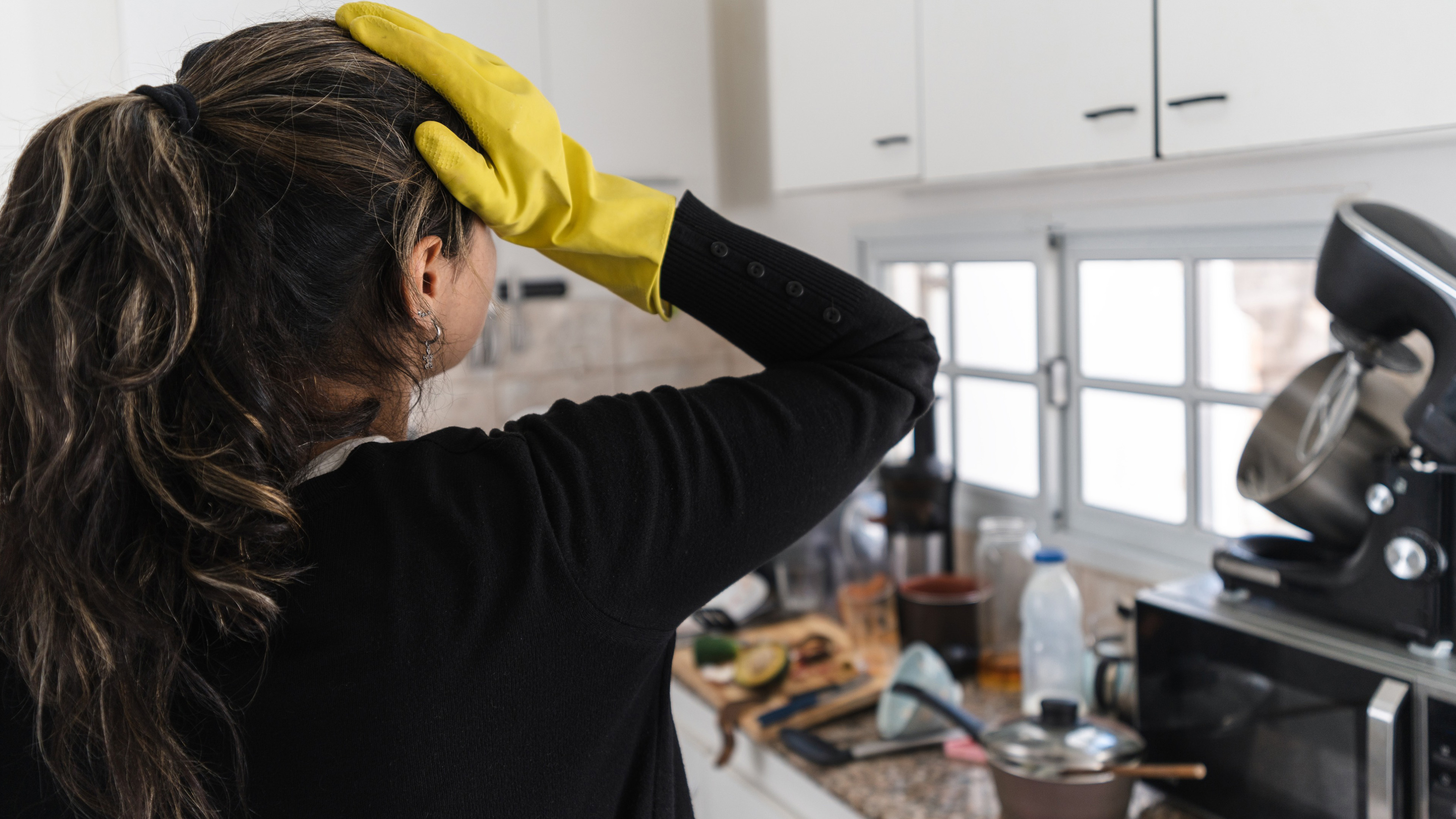 Woman stressed over messy kitchen