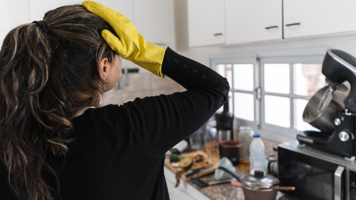 Woman stressed over messy kitchen