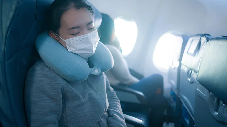 Woman wearing mask asleep on plane