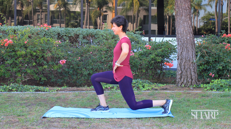 Mujer haciendo ejercicio en una colchoneta de yoga al aire libre