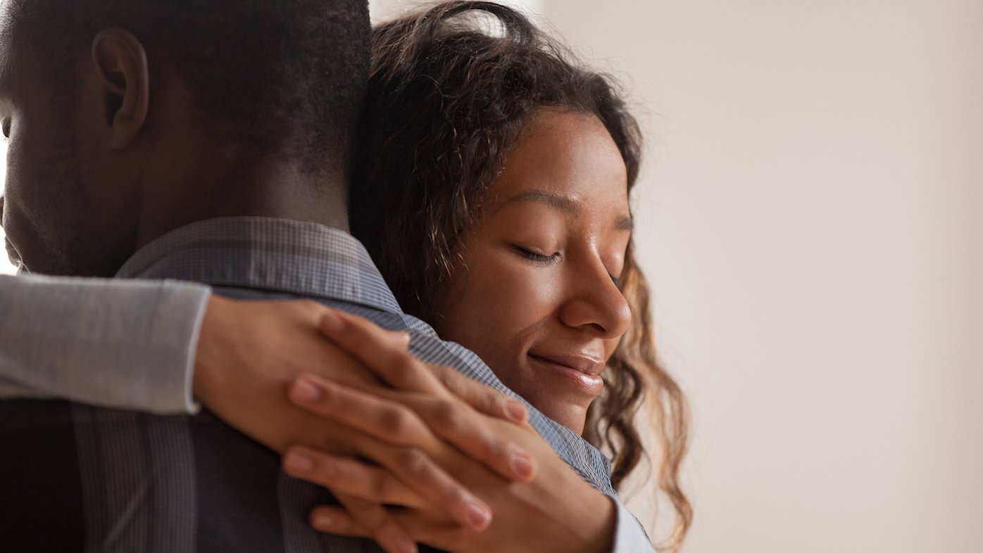 Woman smiling while hugging a man