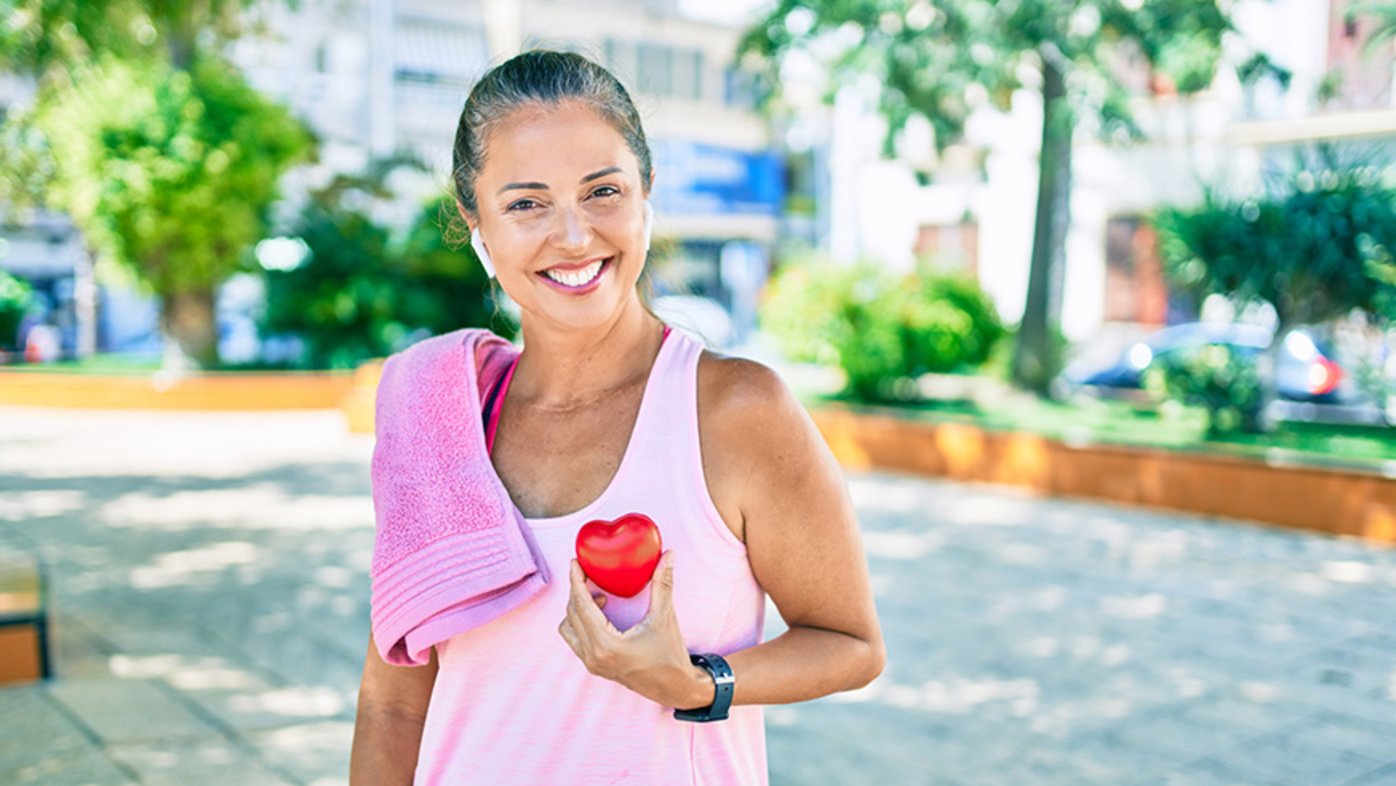 Woman asking for health care holding heart at the park