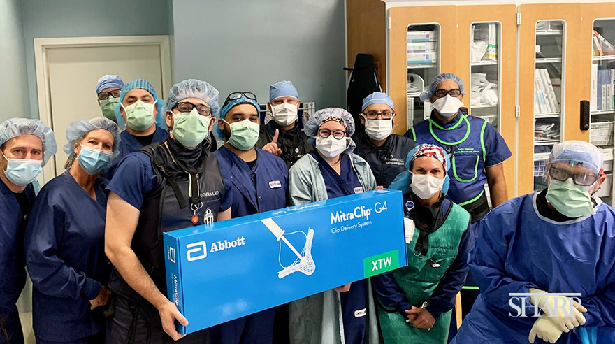 Dr. Jad Omran (left, in black vest), the Sharp Grossmont Hospital cardiac catherization lab team and representatives of Abbott pose with the MitraClip device, a minimally invasive treatment option for patients with mitral valve regurgitation.