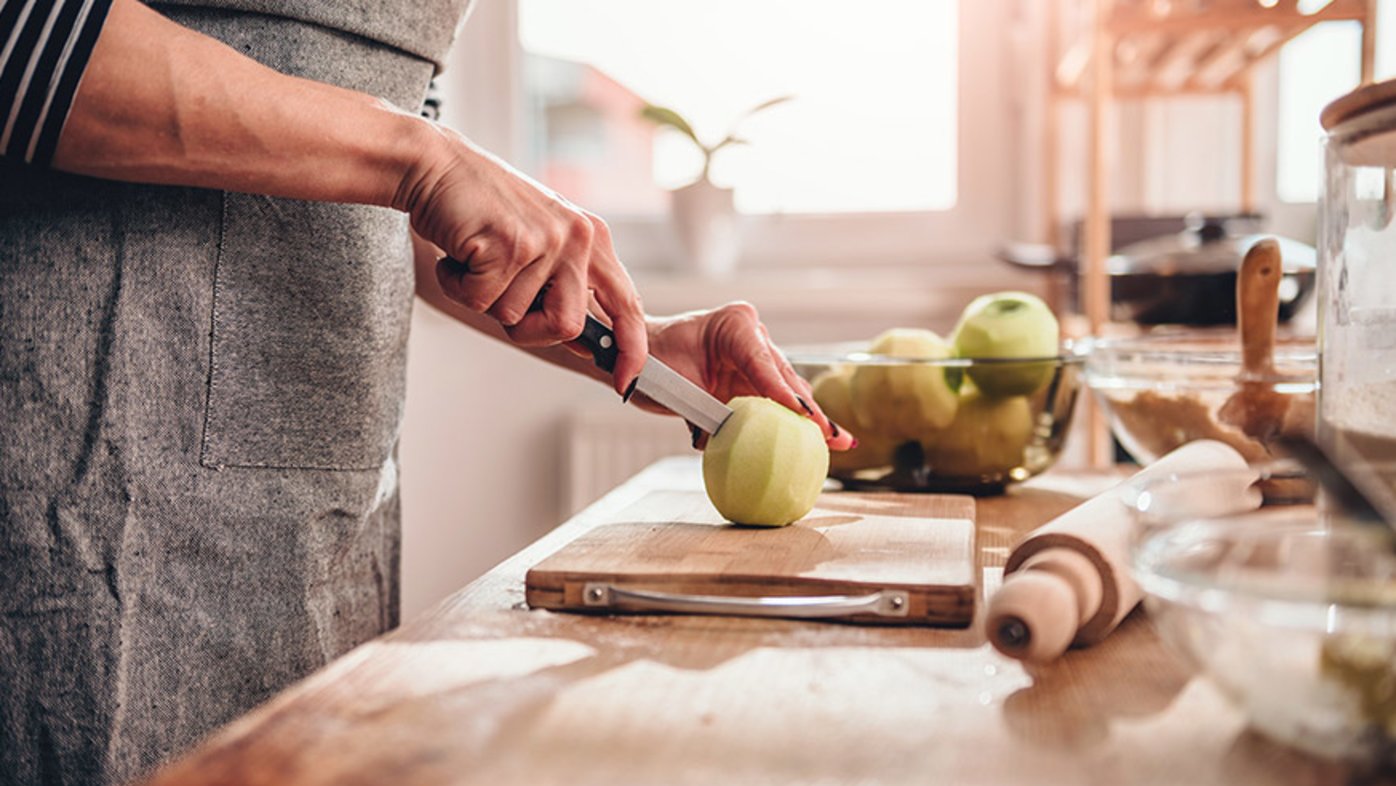 Woman cutting apple on cutting board