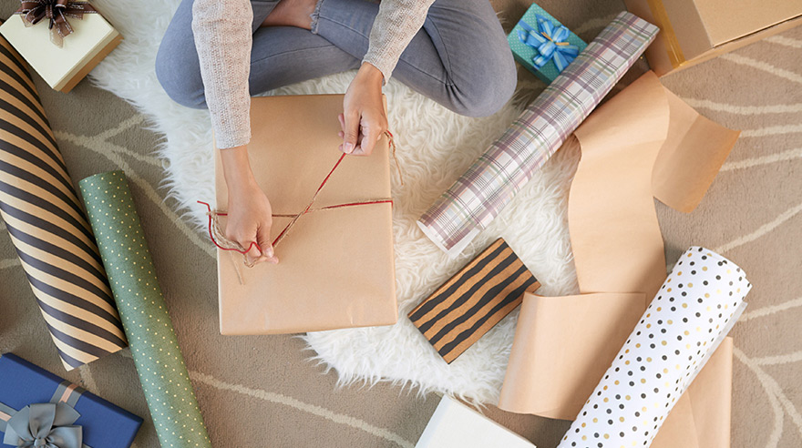 Mujer envolviendo regalos navideños