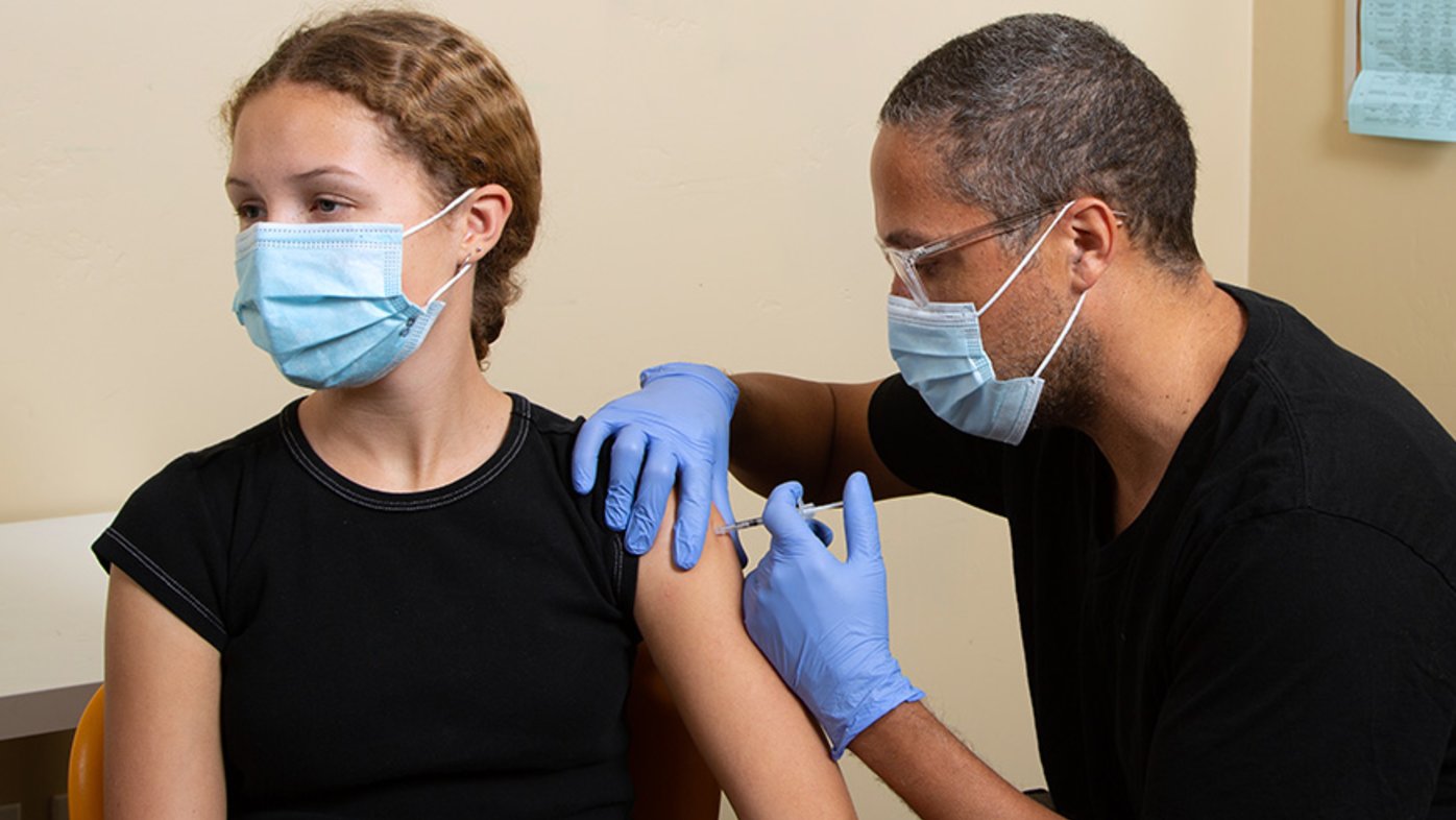 Teenage girl receives COVID-19 vaccine.