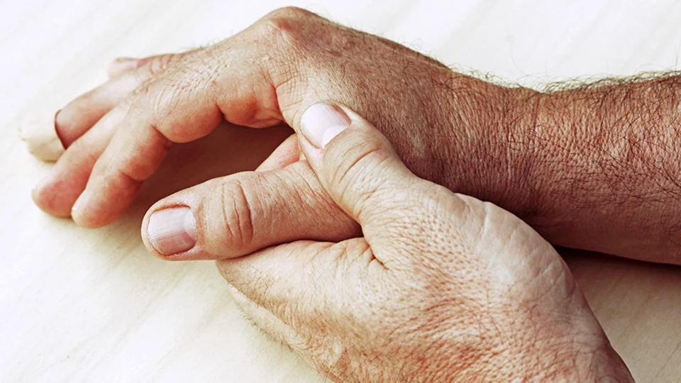 Aged hand holding onto thumb