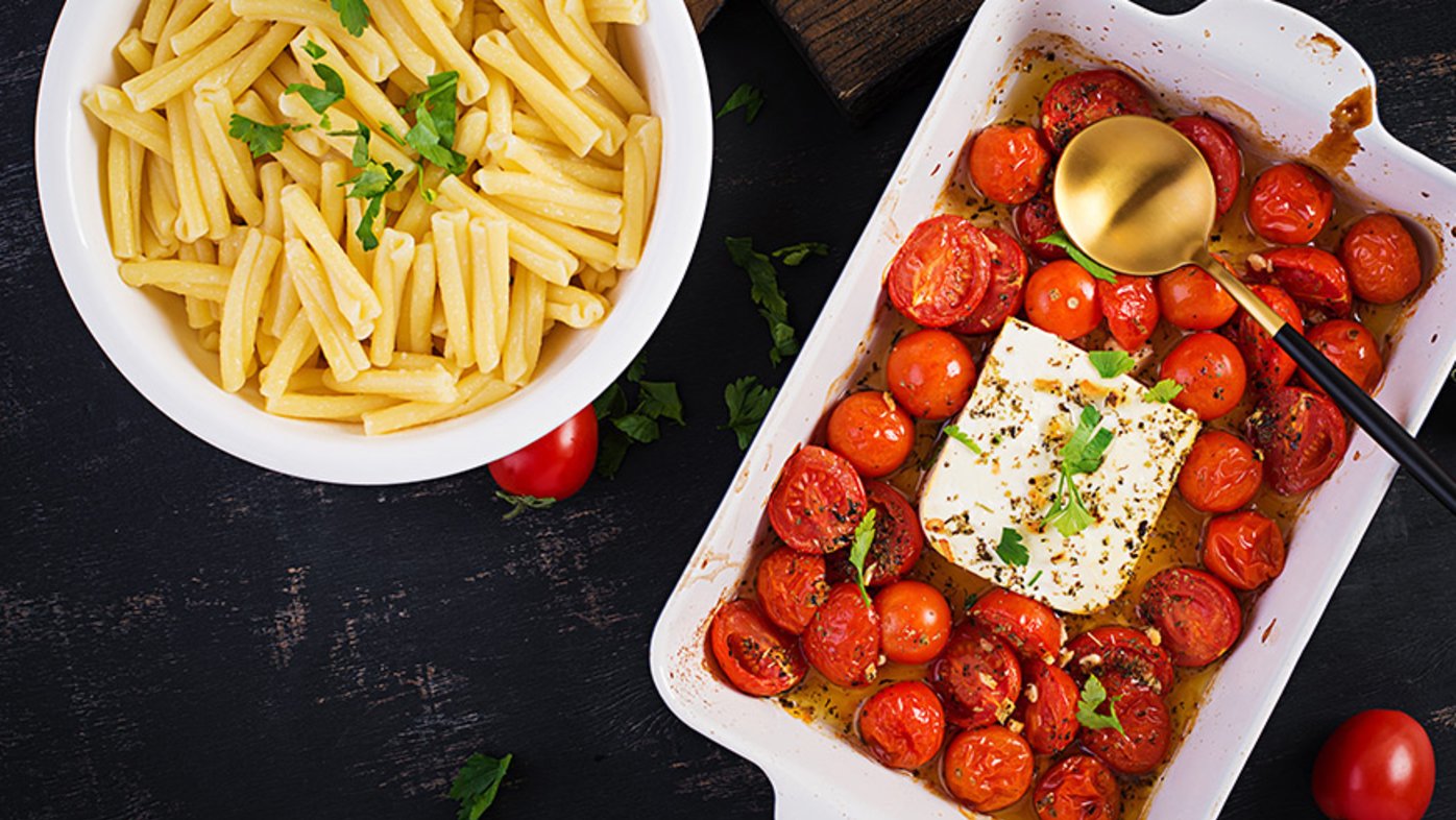 Feta bake pasta recipe made of cherry tomatoes, feta cheese, garlic and herbs in a casserole dish.