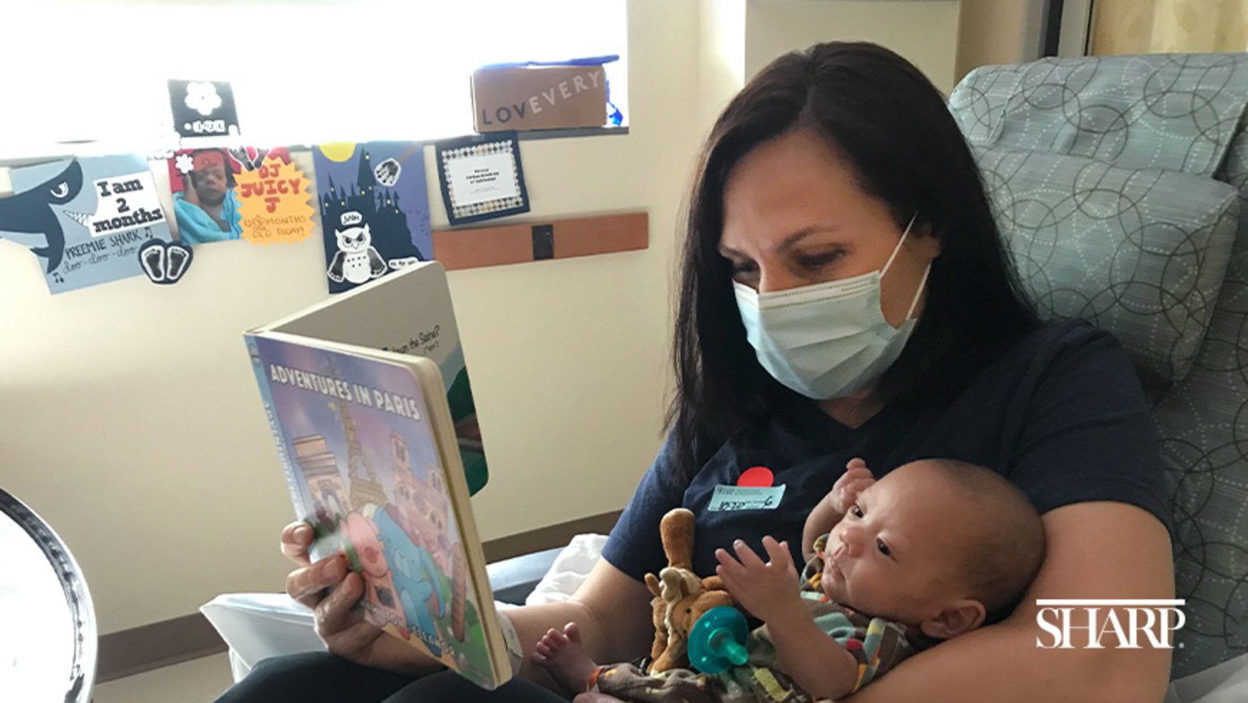 Melissa Stevenson reading a story to baby Jordan in the NICU at Sharp Mary Birch Hospital for Women & Newborns