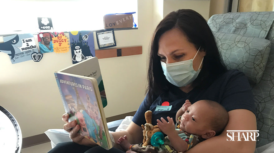 Melissa Stevenson reading a story to baby Jordan in the NICU at Sharp Mary Birch Hospital for Women & Newborns
