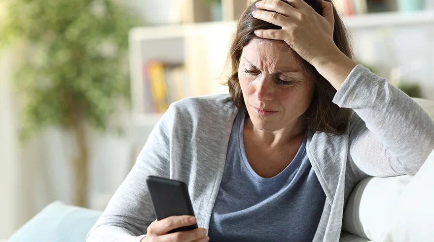 Concerned woman looking at her phone