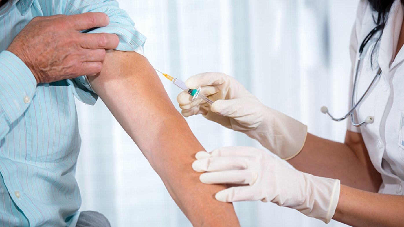 Caregiver administering a shot into a patient's arm