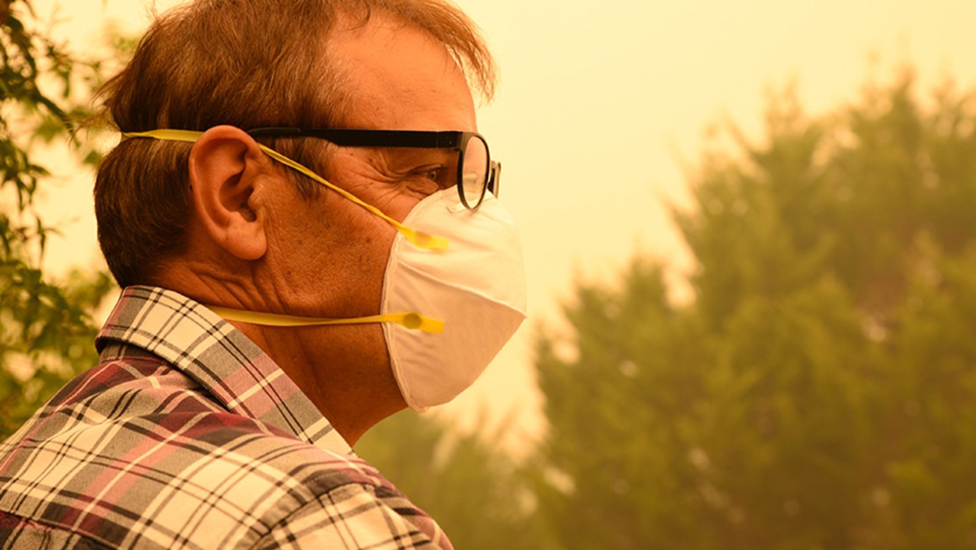 Man wearing glasses and mask in smoky air