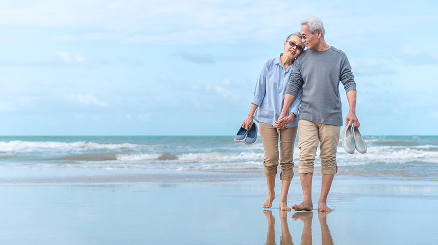 Older couple walking on beach