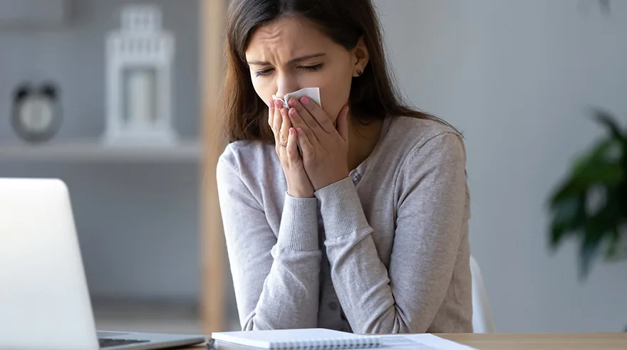 Woman covering her mouth and nose with a tissue