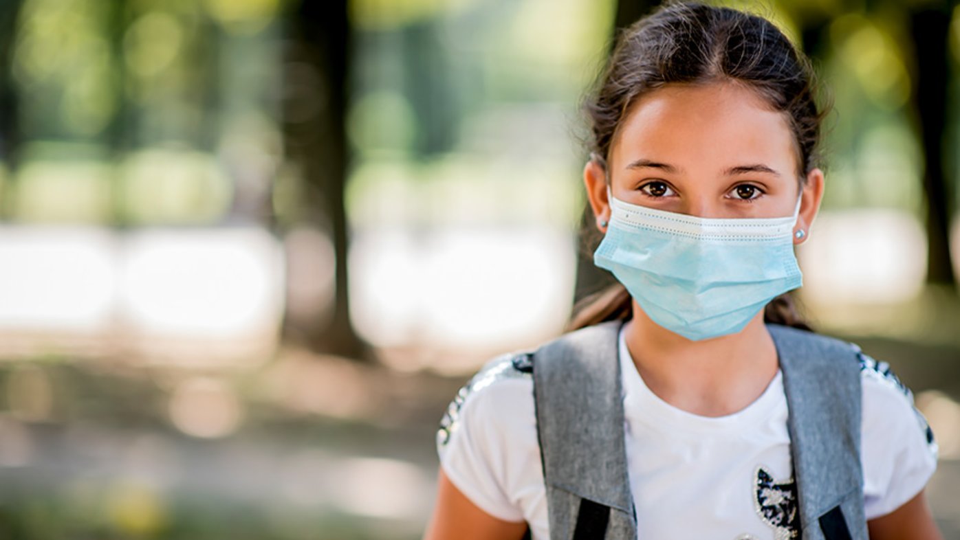 Girl outside wearing backpack and mask