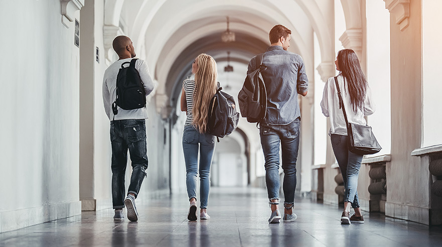 Four young adults walking down hallway