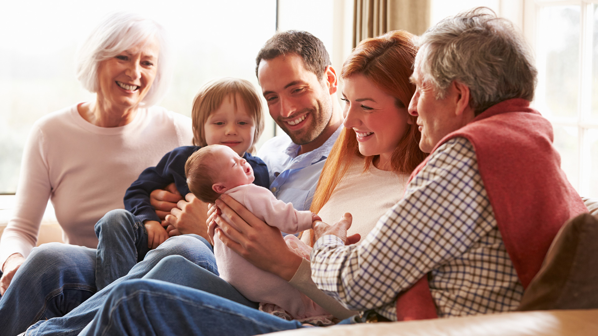 Family smiling around new baby