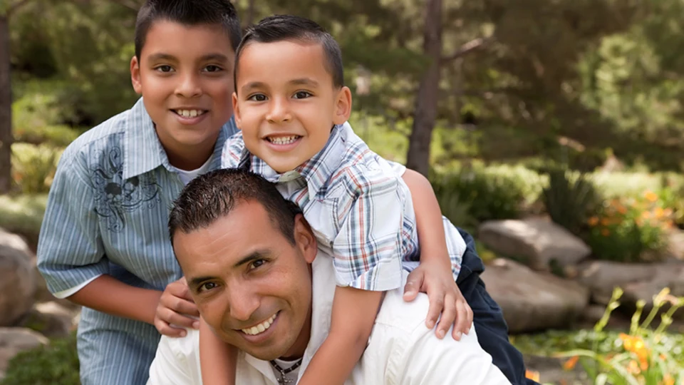 Father with two sons playing in park