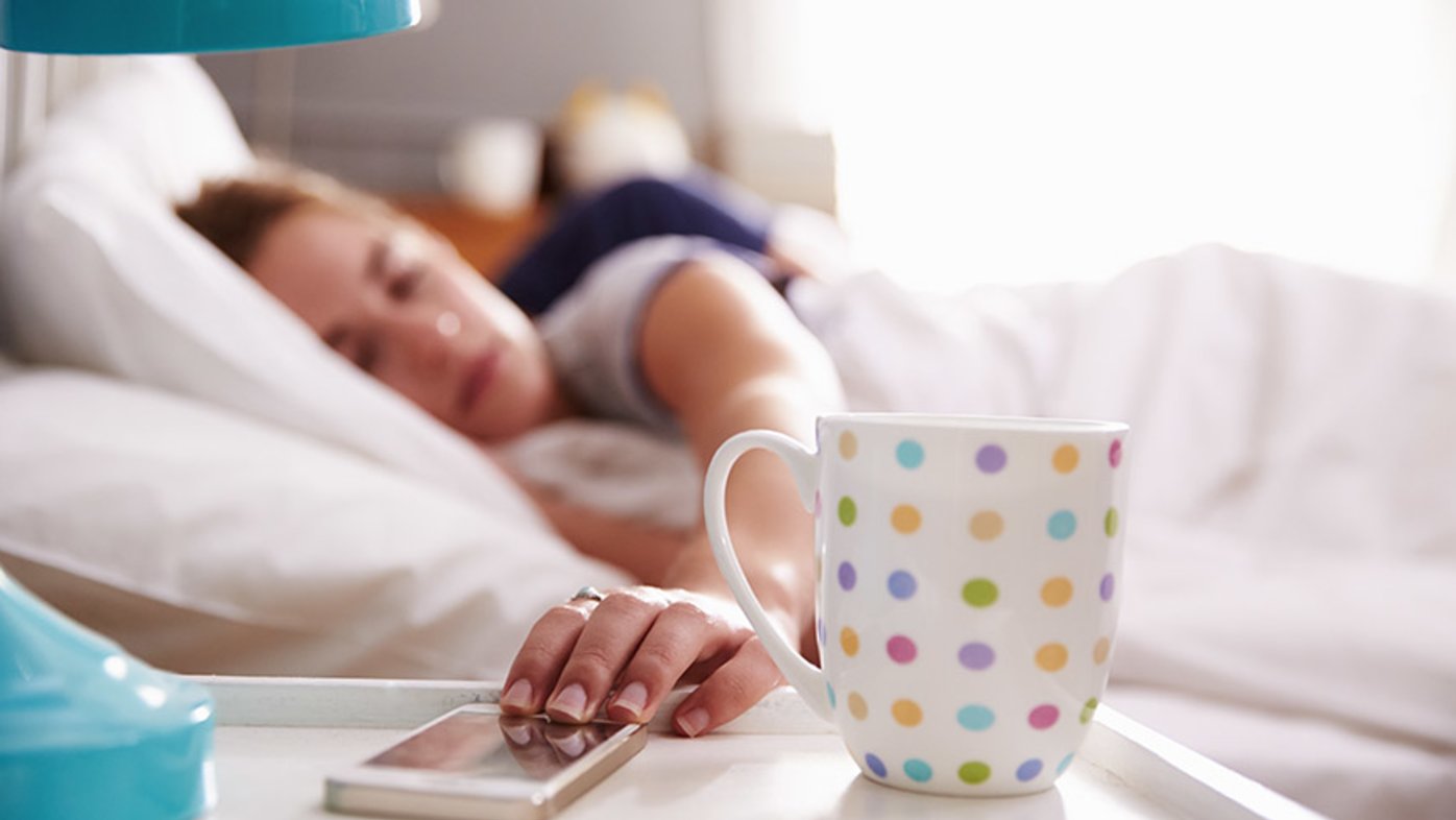 Woman with smart phone in bed