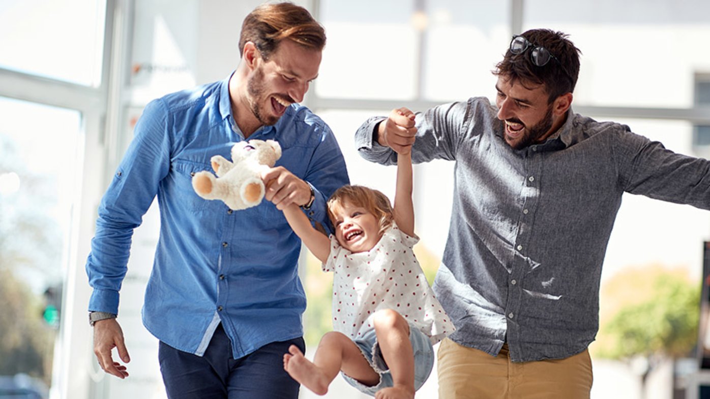 Happy couple swinging their child