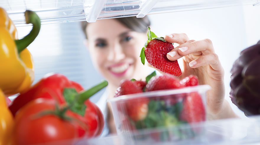 Strawberries and bell peppers in a refrigerator