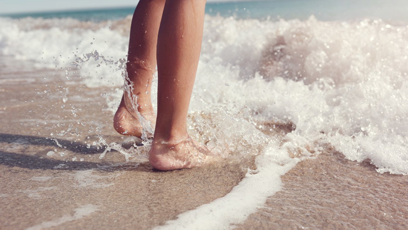 Feet splashing in ocean