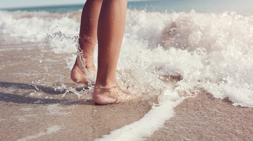 Feet splashing in ocean