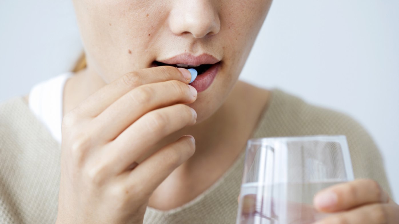 Person with water taking medication