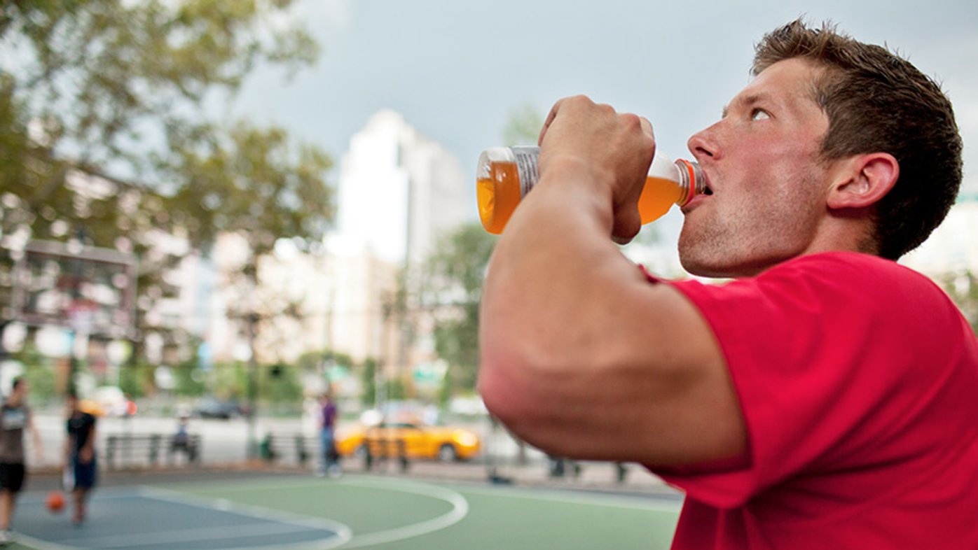 Man drinking sports drink while exercising
