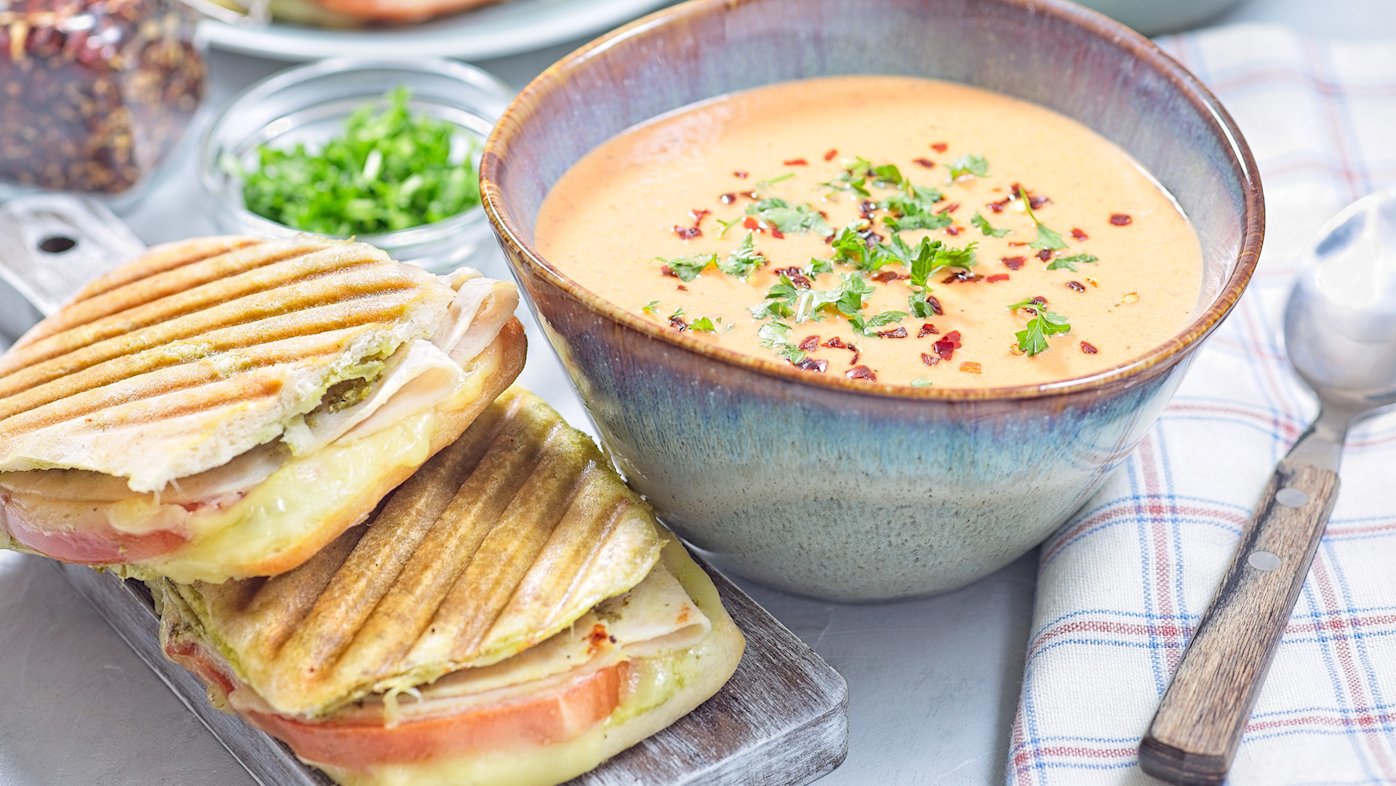 Creamy soup with a grilled turkey and cheese sandwich