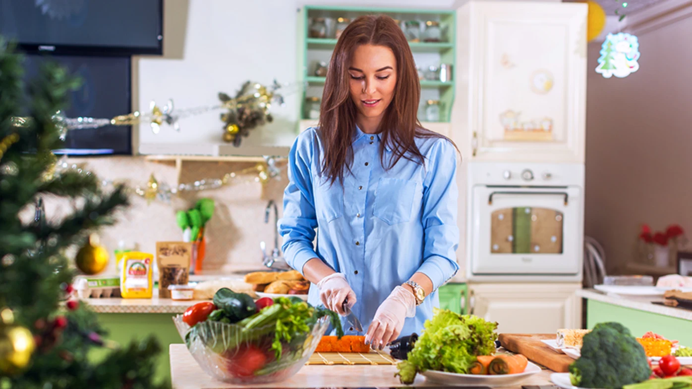 Mujer picando verduras en la cocina