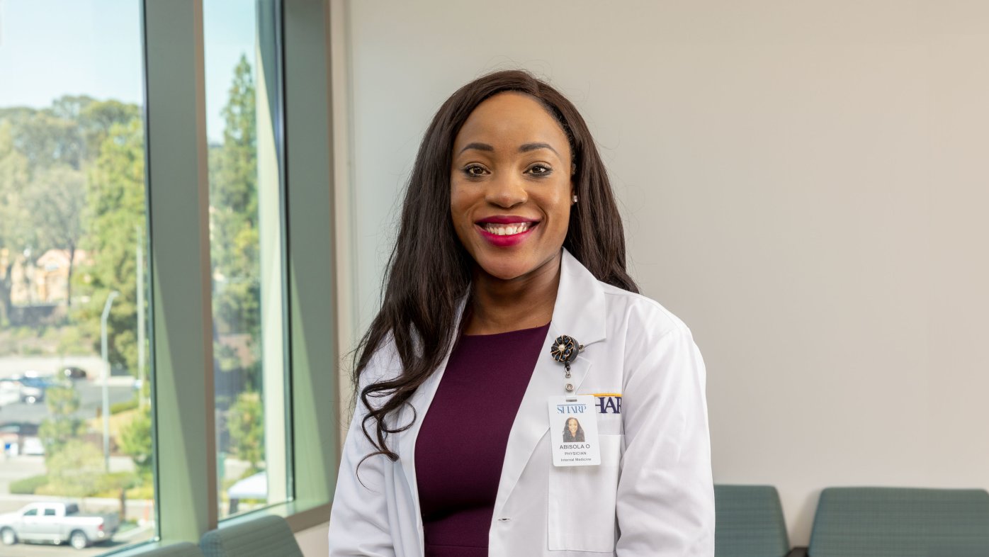 Dr. Olulade smiling and standing in lobby waiting room.