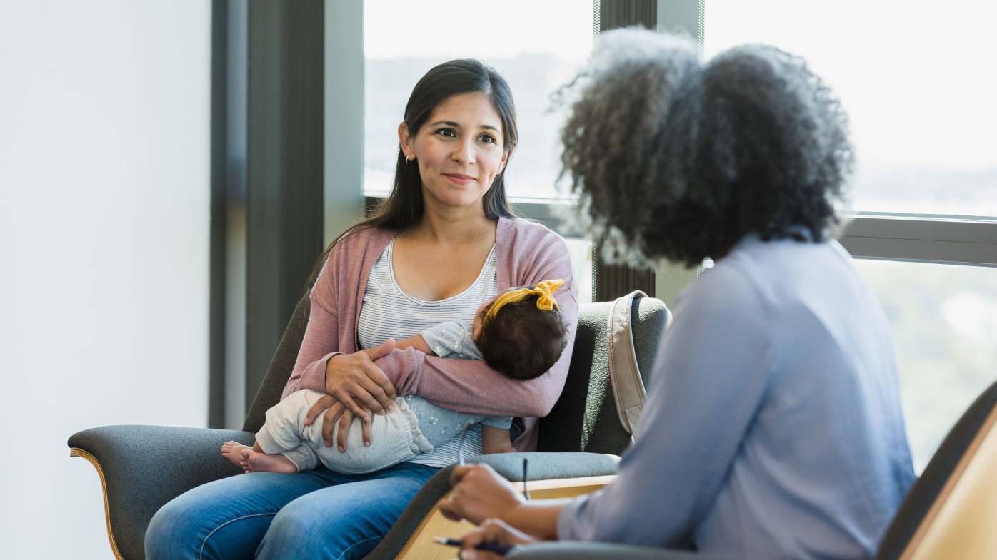 Mother with newborn receiving in-person counseling support with a specialized psychiatrist.