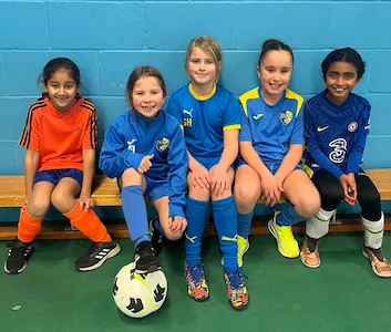 Young girls sitting together after grassroots football training