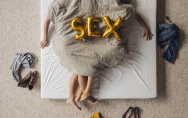 Paar auf dem Bett liegend unter der Bettdecke