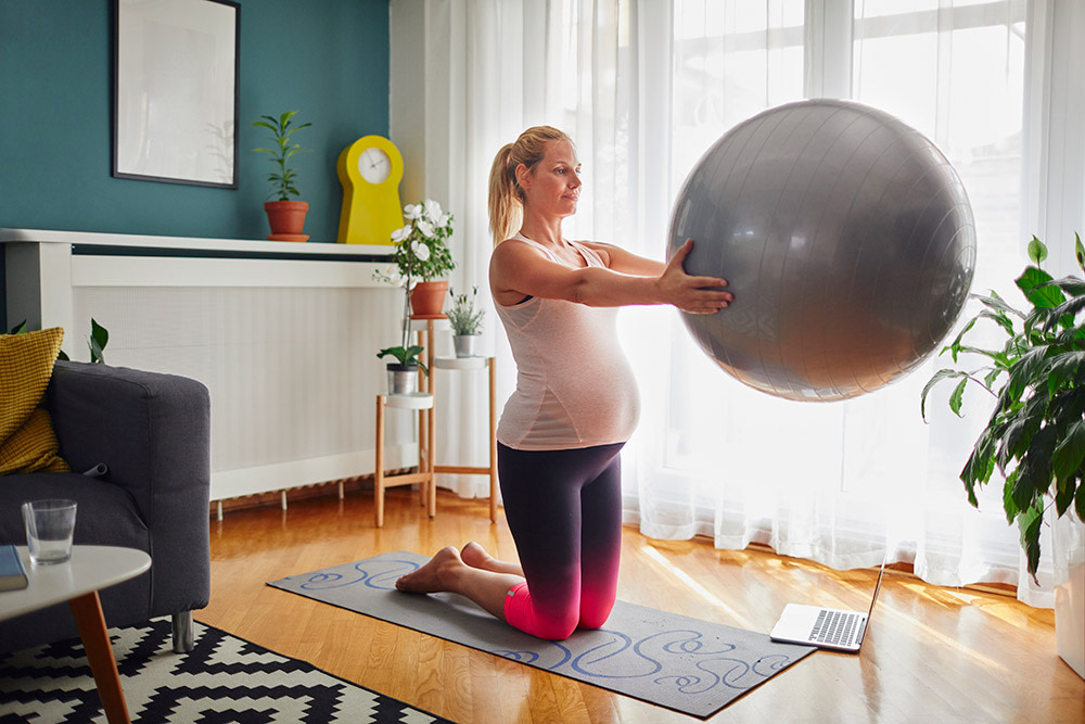 Schwangere Frau mit Gmynastikball