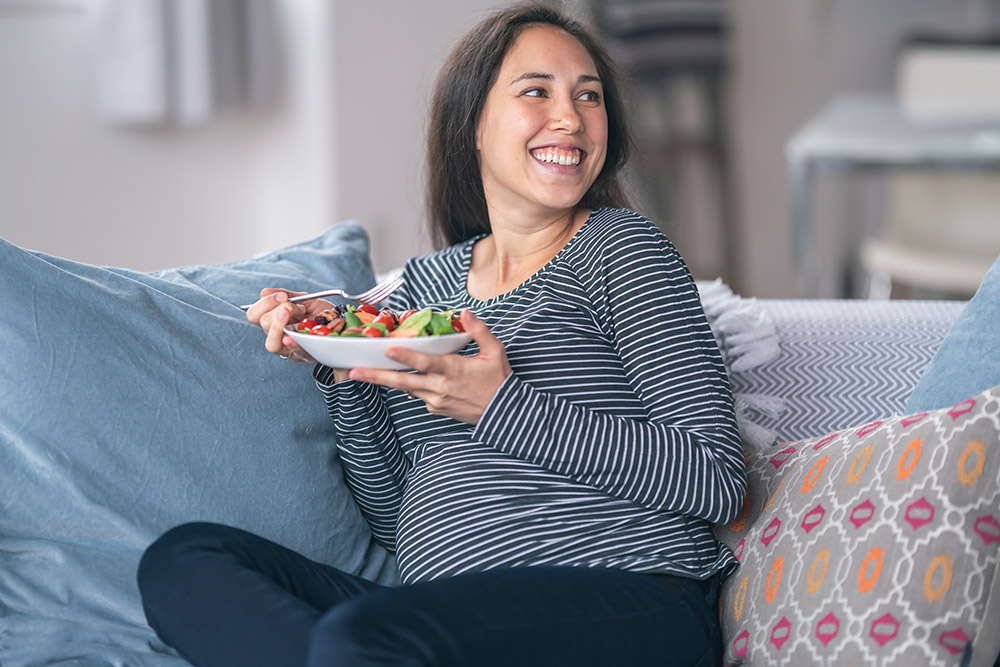 Frau auf Sofa mit Salat